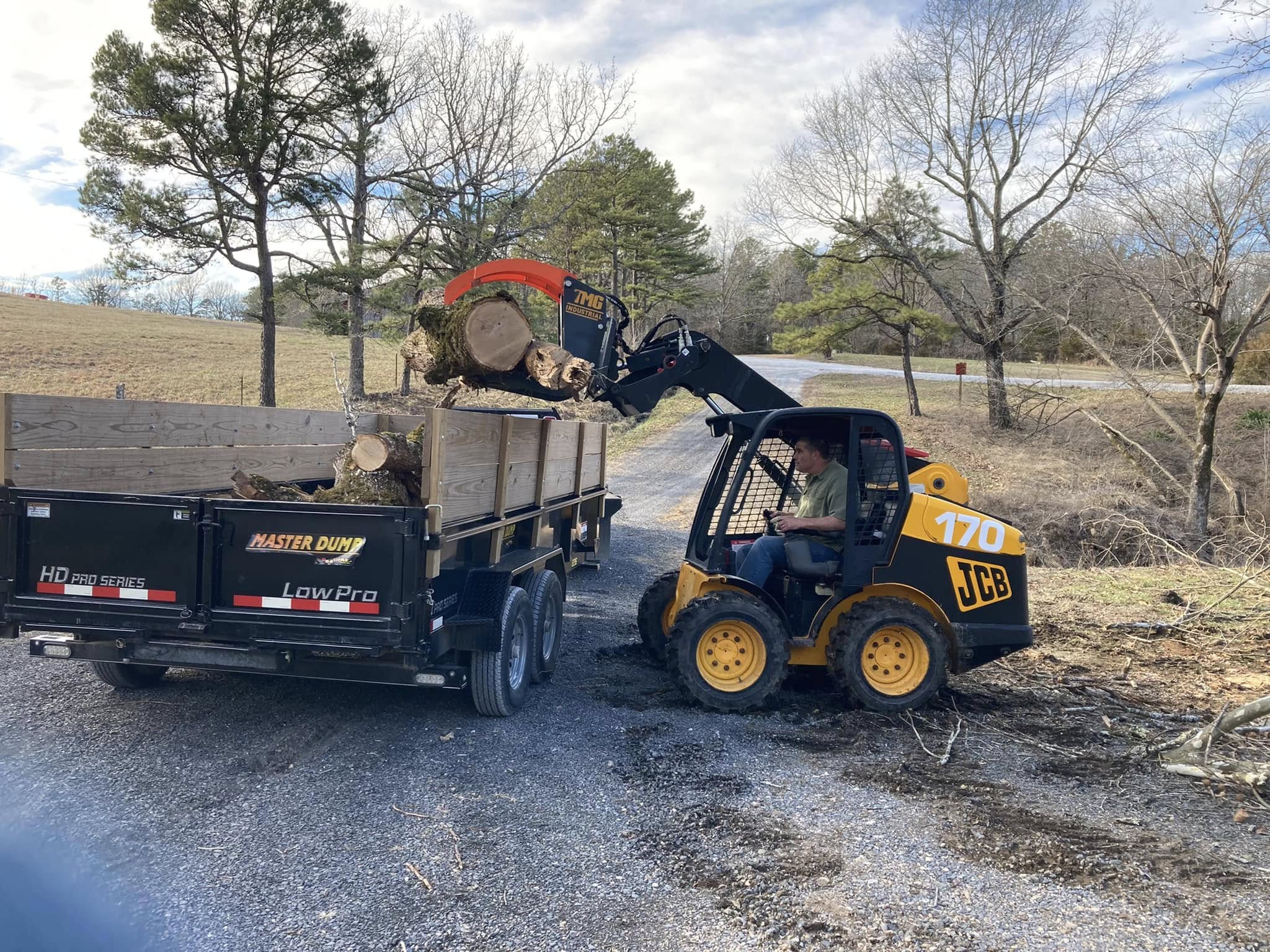 Heavy timber grapple loading logs into trailer