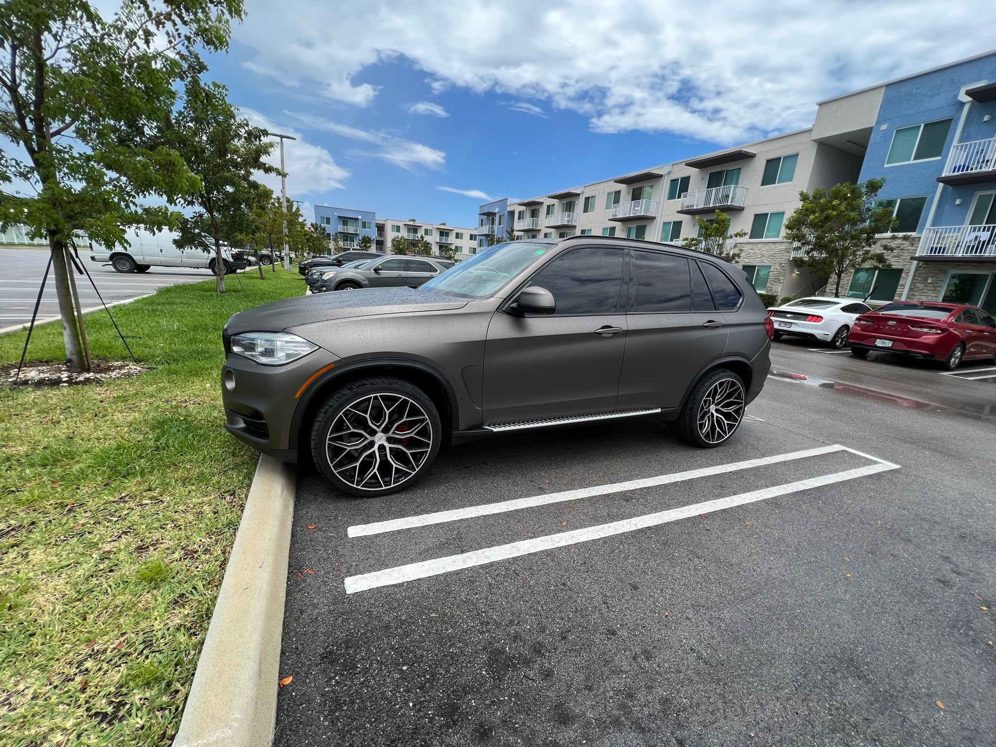 Side profile of BMW X5 wrapped in satin charcoal bronze metallic vinyl by Specialized Wrapping Design in Miami FL