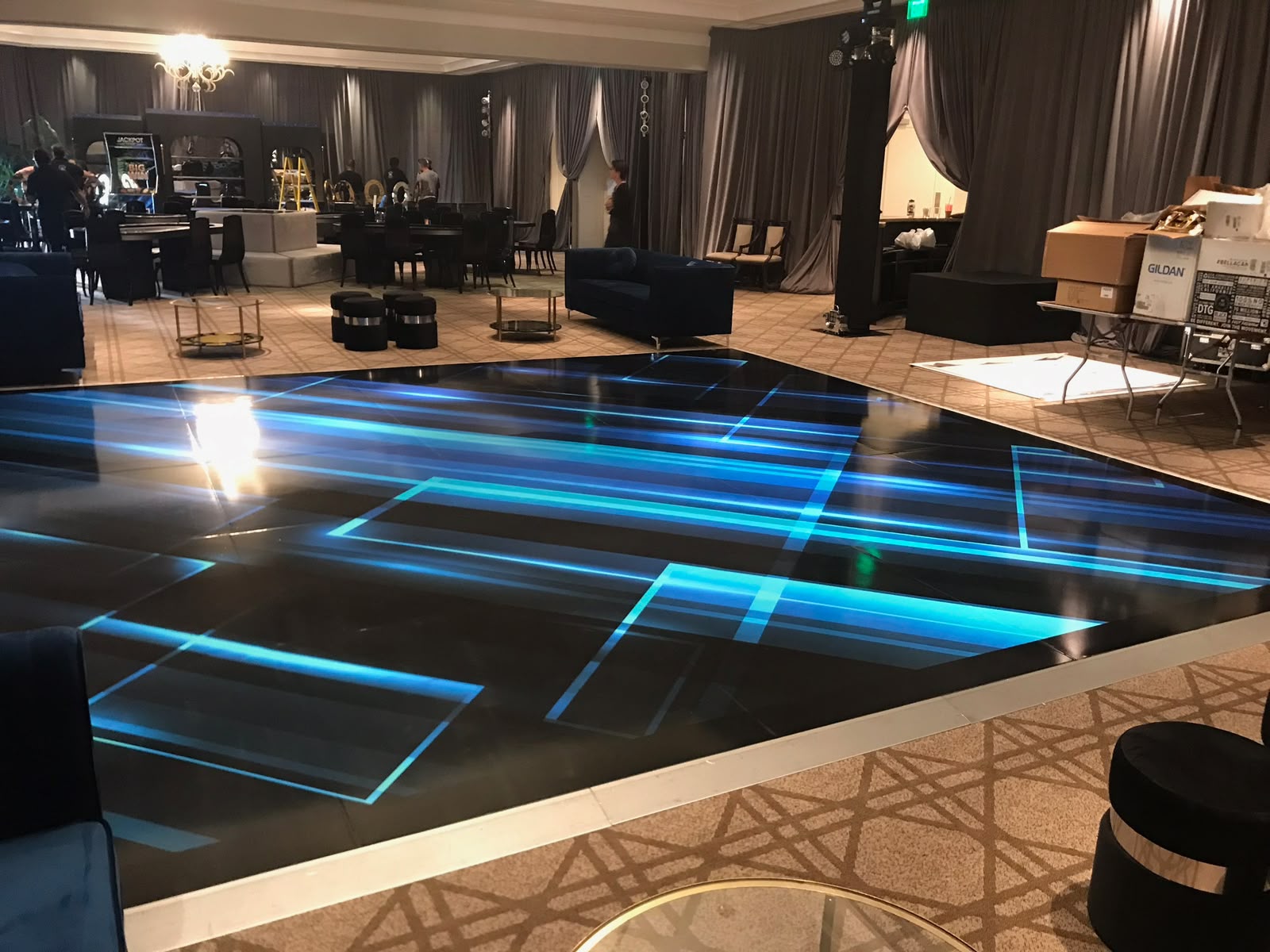 High-tech neon cyan and electric blue geometric dance floor wrap installed for luxury VIP event in Downtown Miami