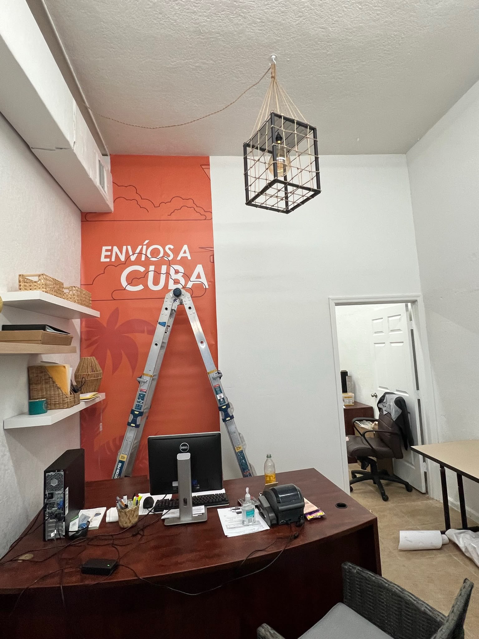 Commercial shipping agency office feature wall wrap Envíos a Cuba in coral red and white installed in Hialeah FL