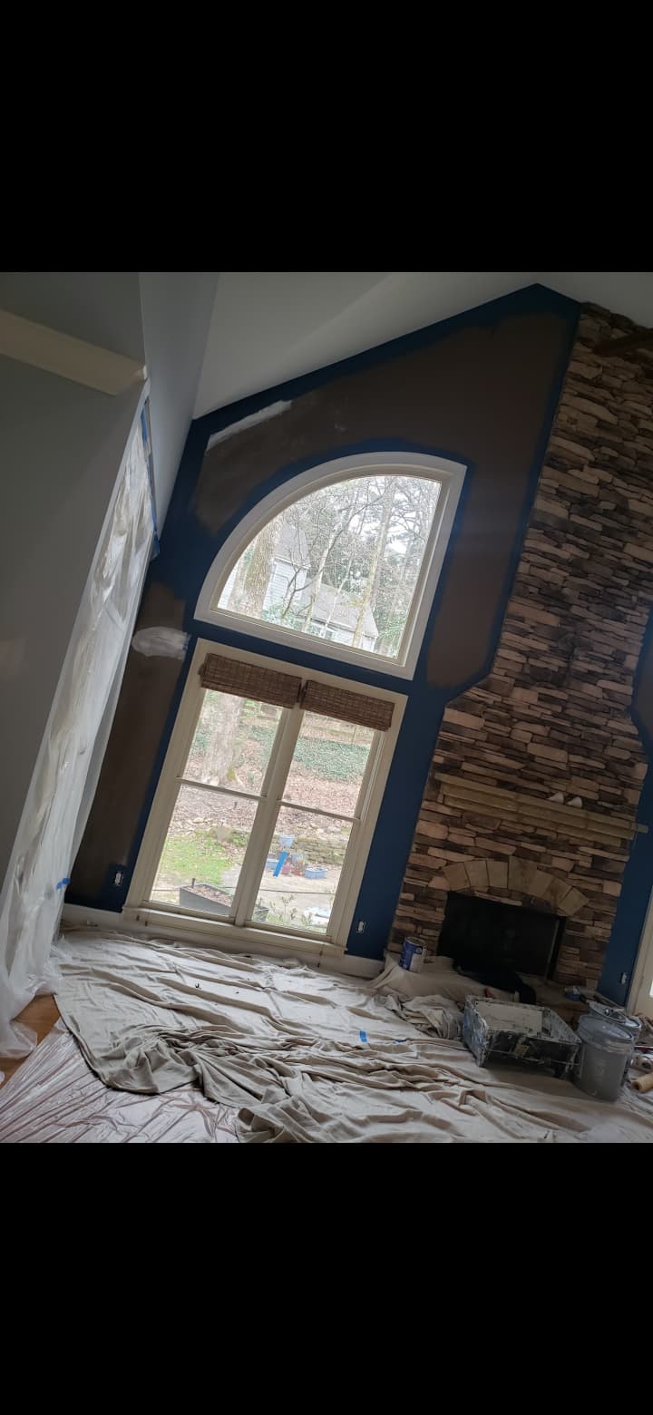Precision tape prep, floor protection and interior accent wall painting around stone fireplace and arched windows in Cedartown GA