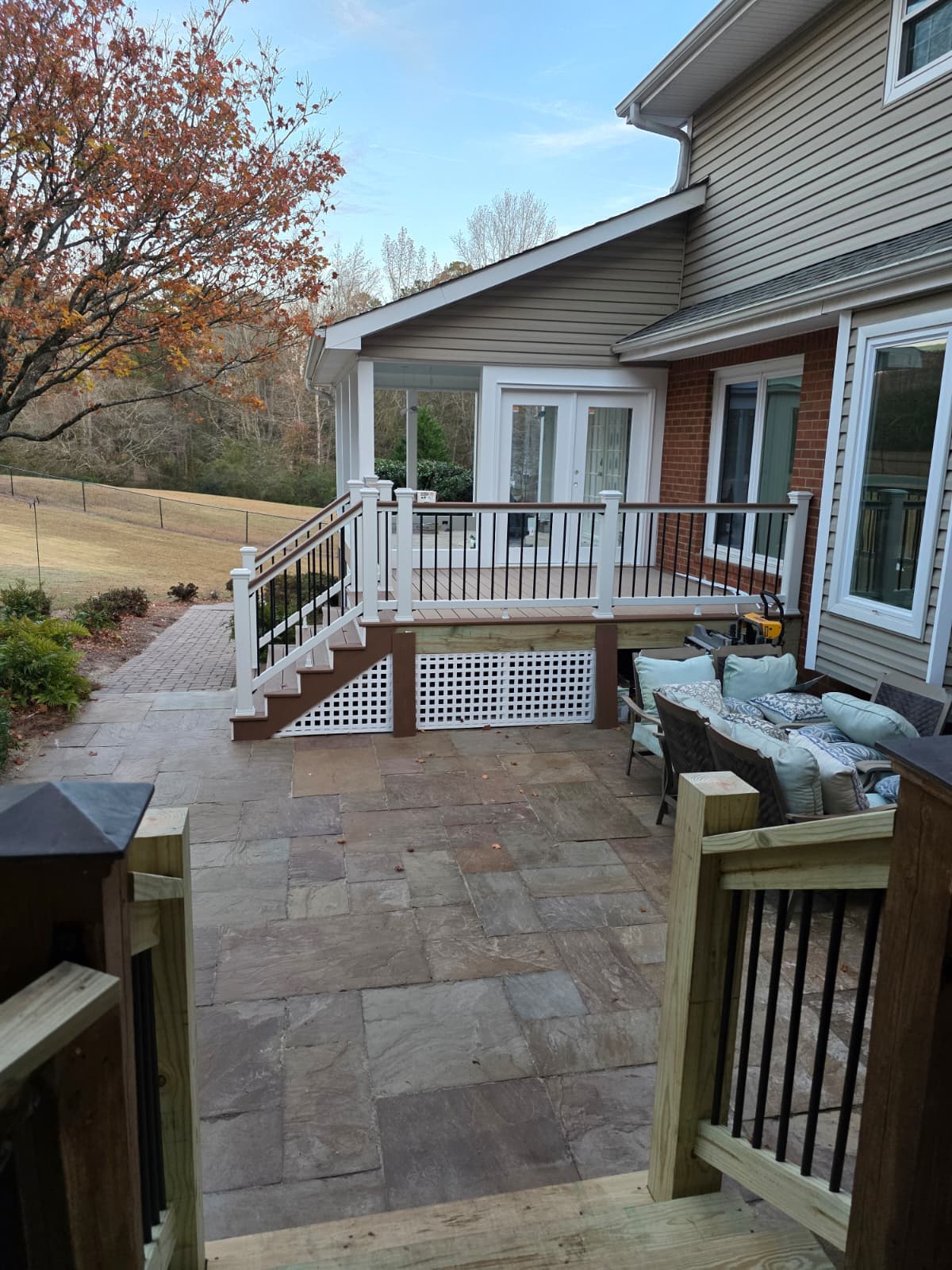 Finished covered deck porch with French doors, white lattice skirt, and stone patio in Cartersville GA