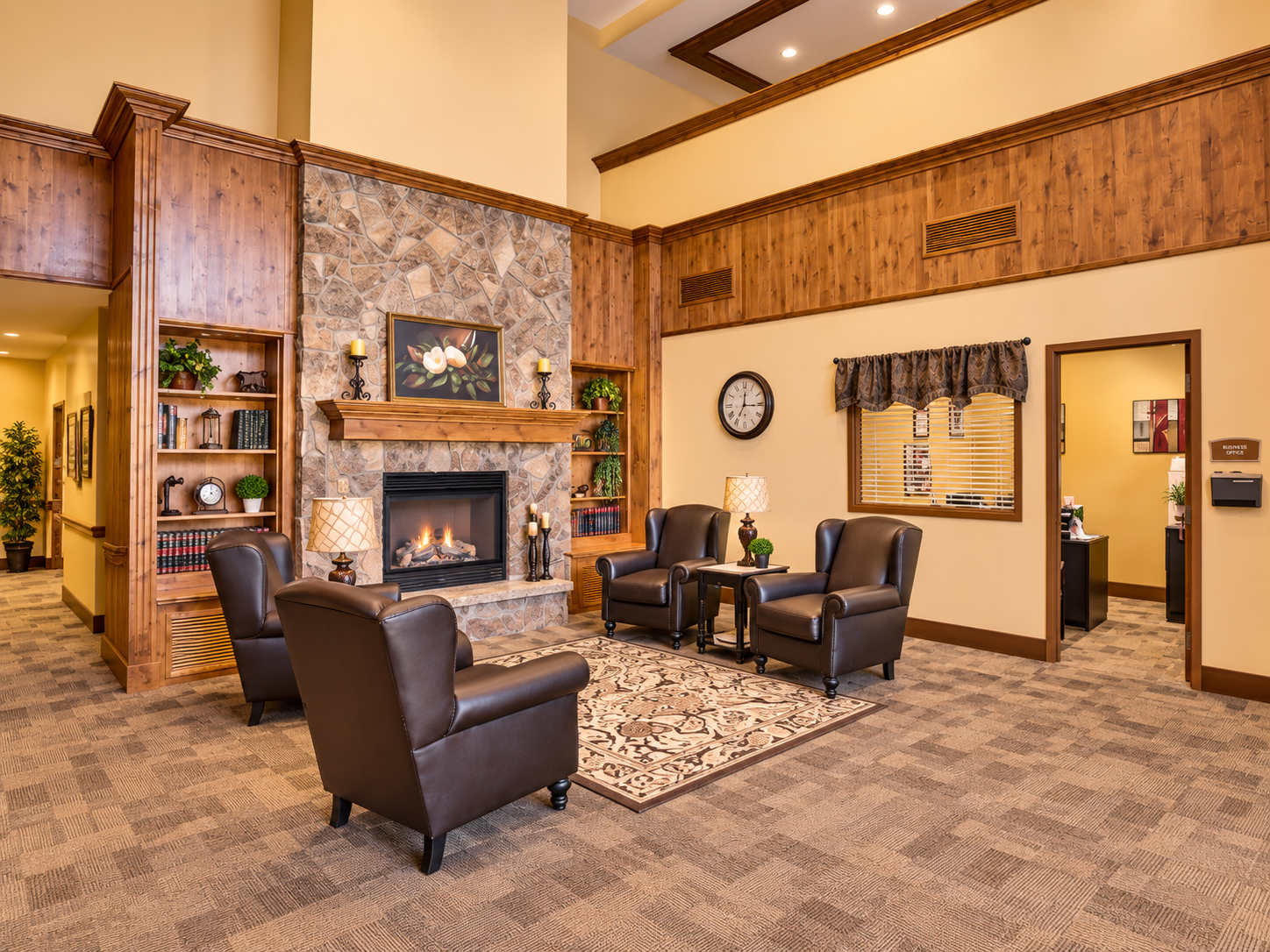 Seasons Health & Rehab warm, elegant living room lobby with stone fireplace and library shelving
