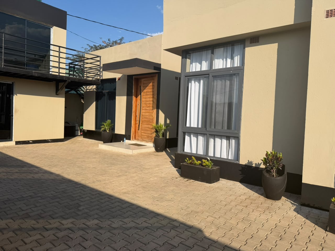 Courtyard view showing private apartment entrance, large windows, and rooftop terrace