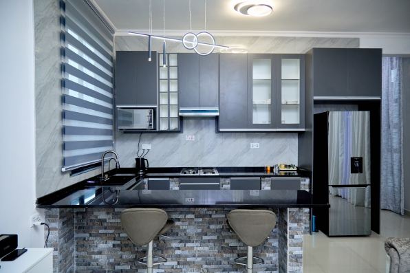 Modern kitchen with dark cabinets, black counter and breakfast bar