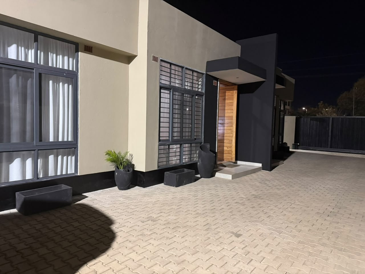 Private apartment entrance and paved parking lit at night
