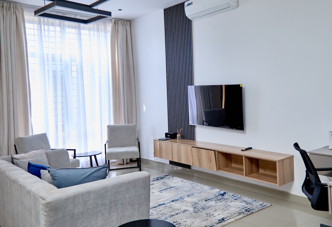 Spacious living room with wooden TV unit and feature wall