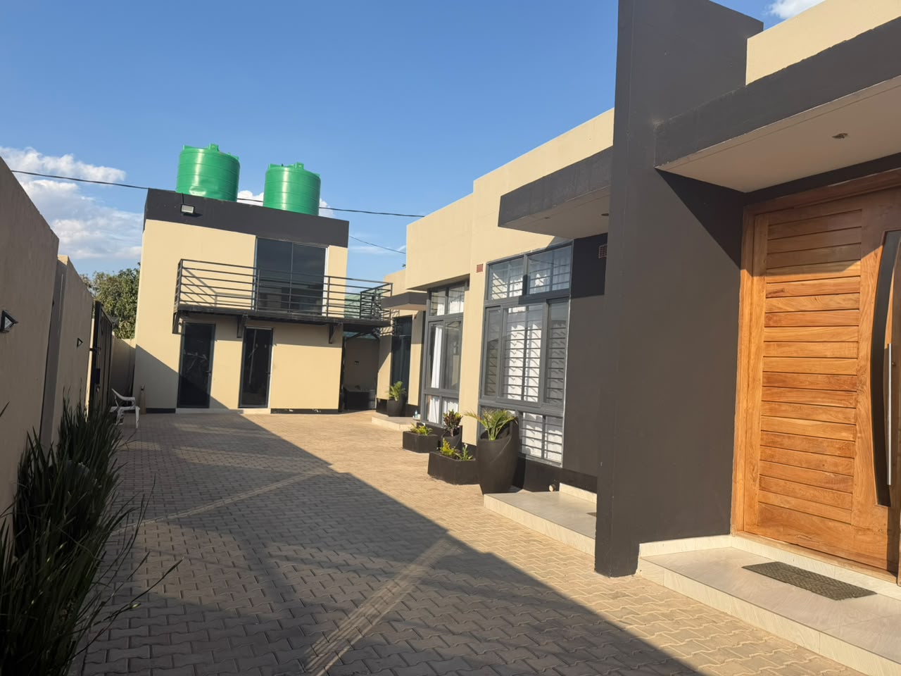 Paved courtyard with apartment entrances and rooftop terrace lounge