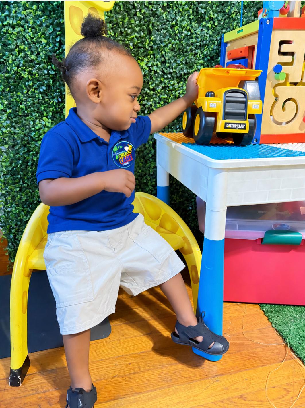 Toddler engaging with sensory play table and toy truck