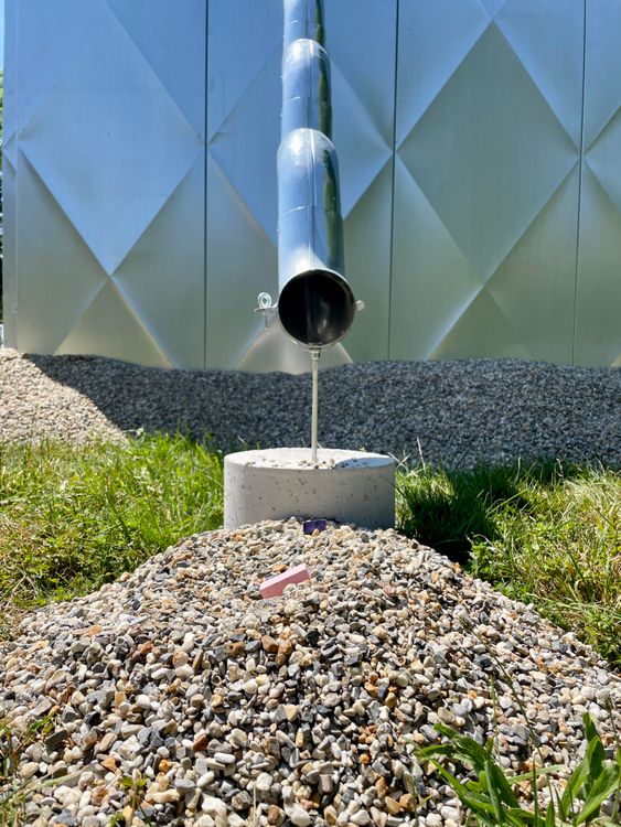 Outdoor drainage pipe releasing onto gravel bed