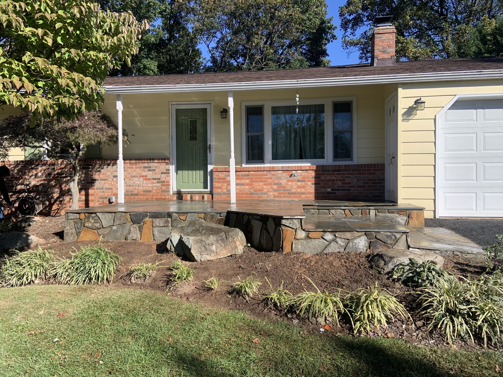 Front view of stone-faced porch landing and broad stone steps