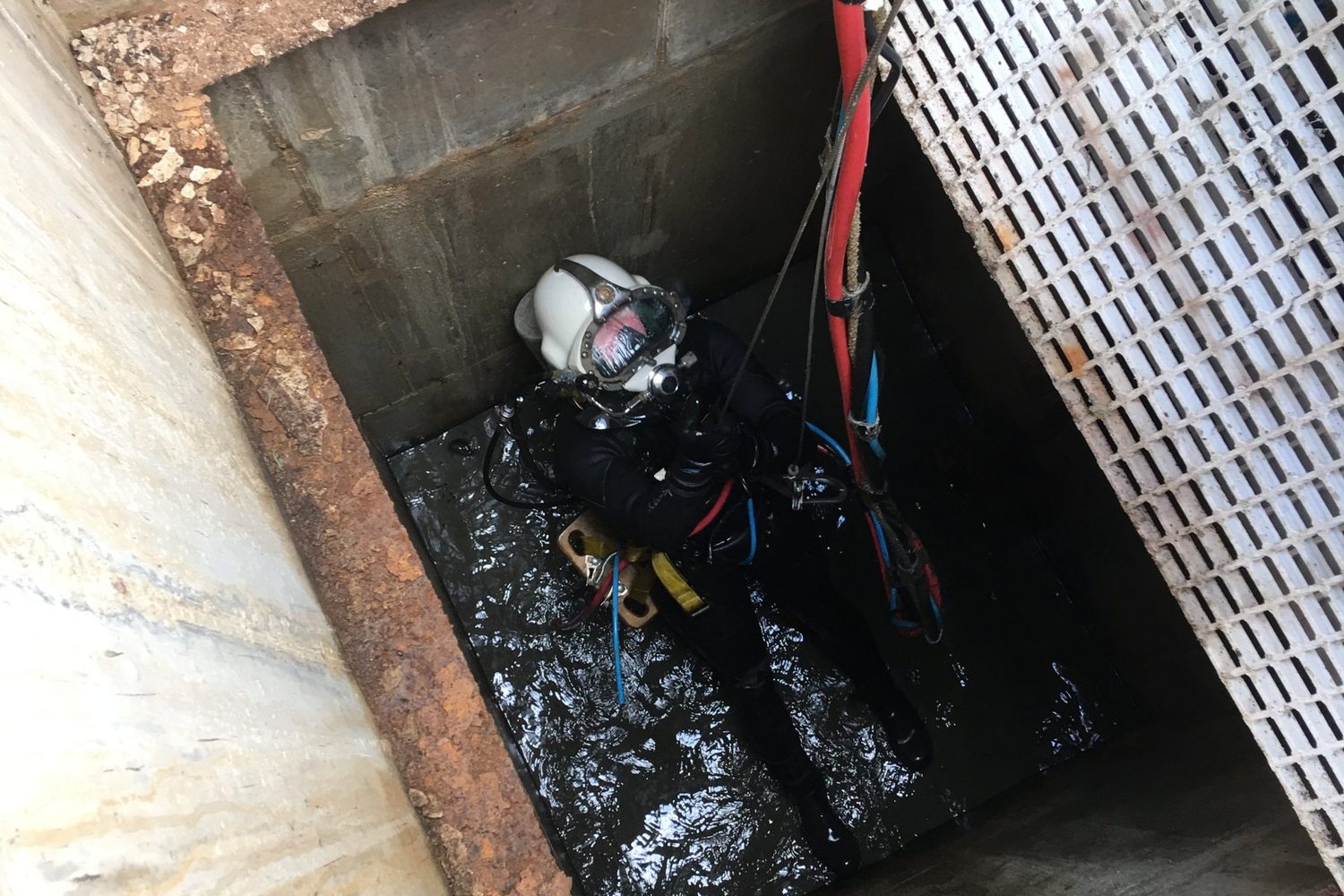 Commercial diver in a helmet preparing to inspect dam