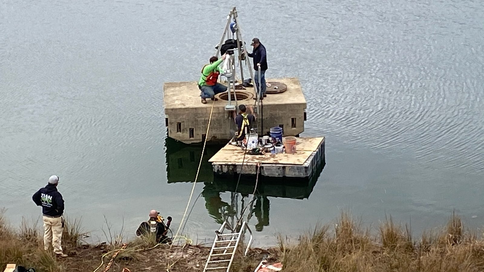 Crew on a float at a dam intake tower.