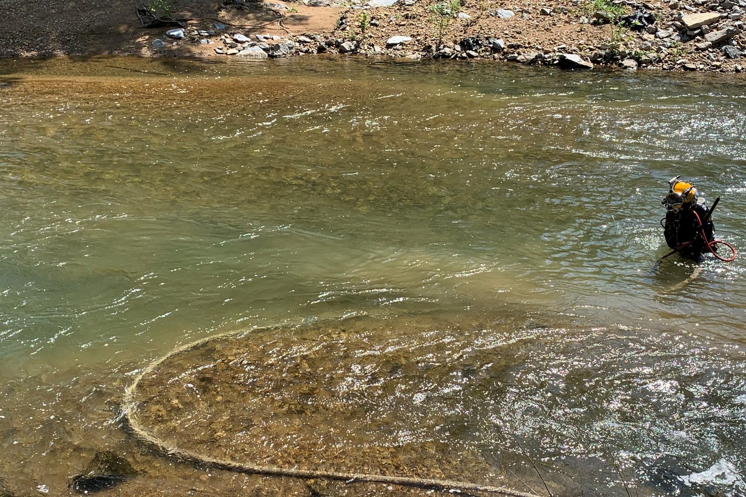 Diver and hose in a river.