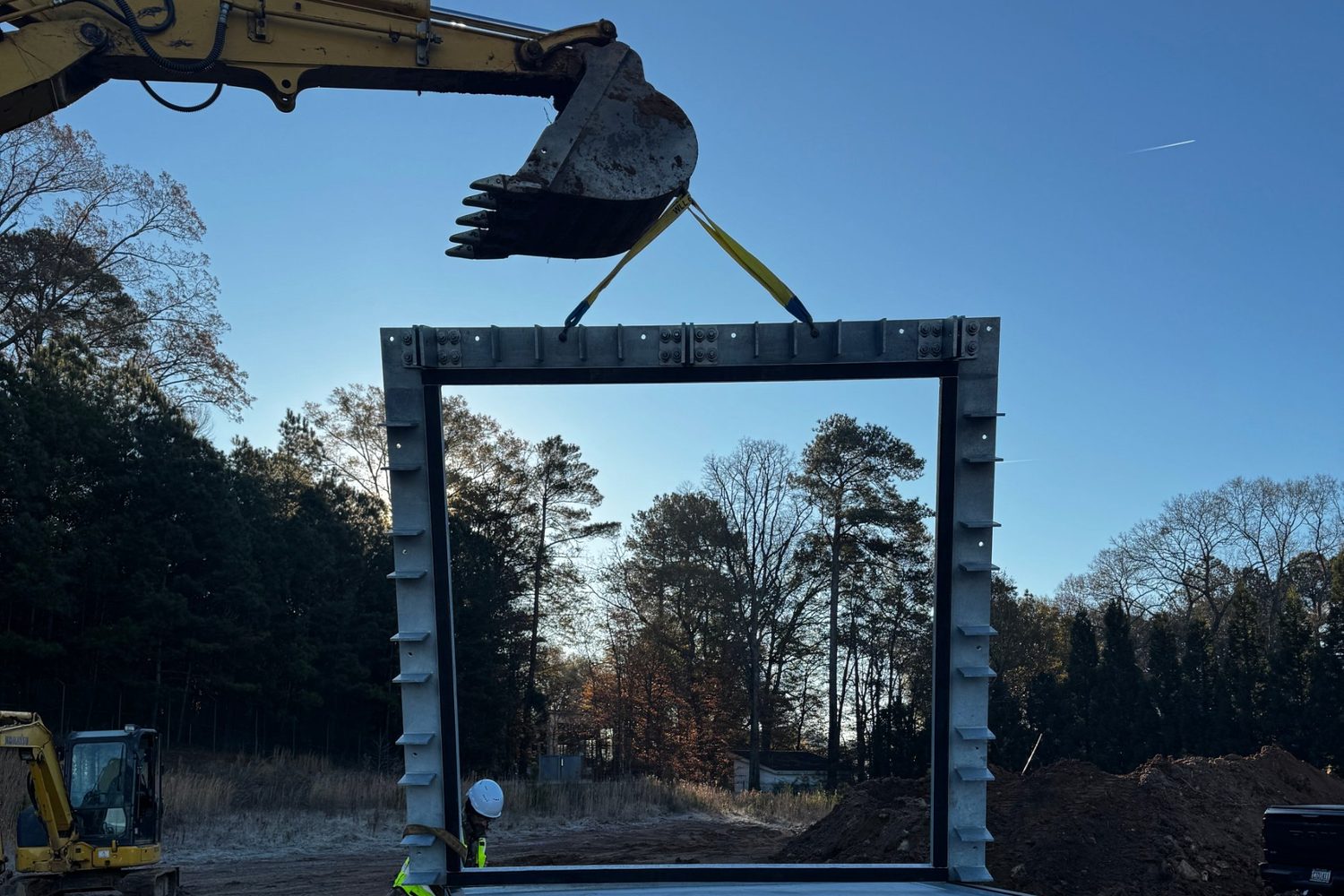 Crew lifting a gate frame at a dam control structure.