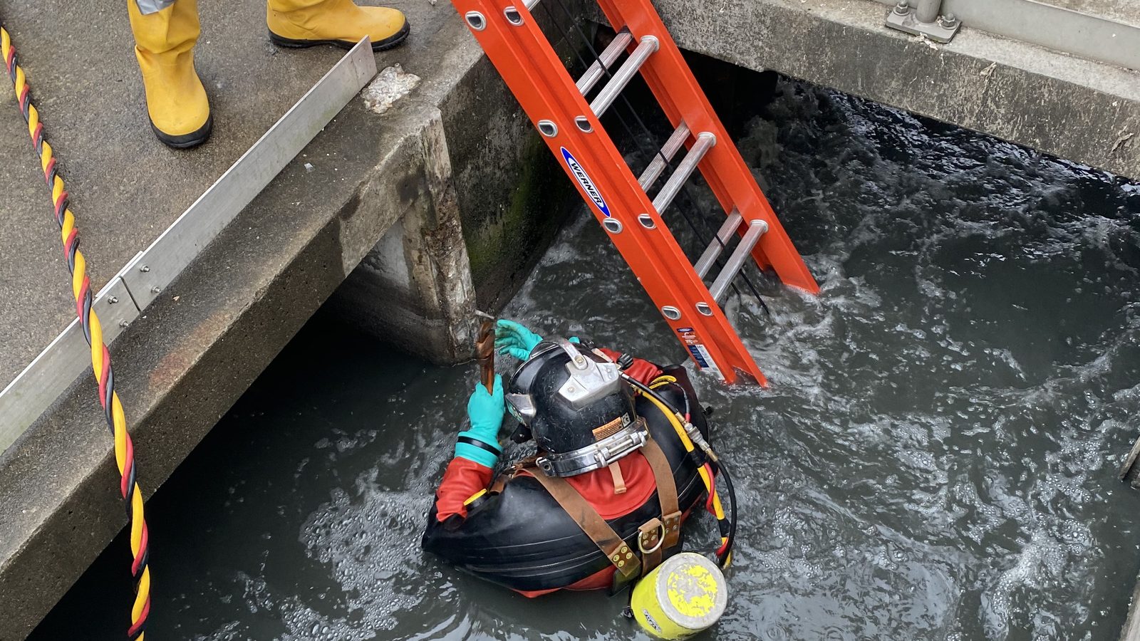 Commercial diver working in contaminated water at a treatment facility.