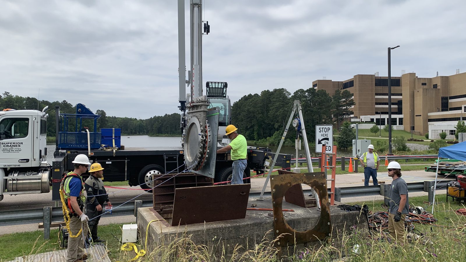 Crew setting a gate valve at a dam.