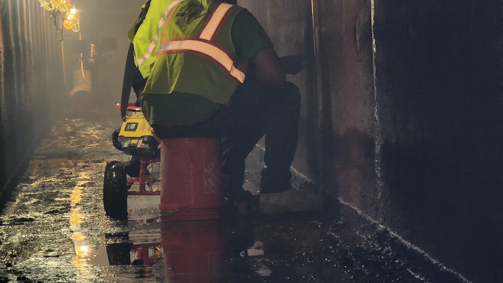 Crew working inside a dam outlet conduit tunnel.