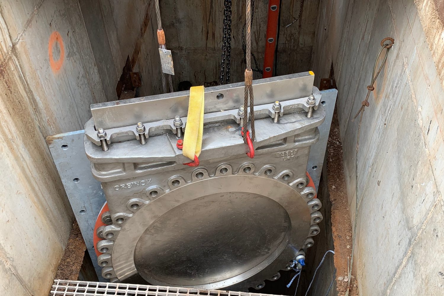 Gate valve lowered into a concrete vault.