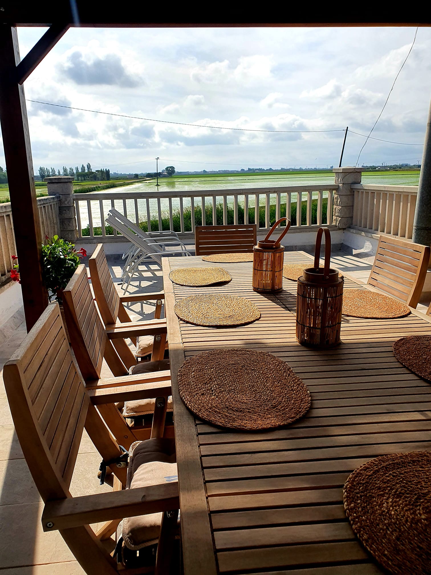 Terraza exterior de nuestro alojamiento turístico con mesa de madera y vistas al campo.