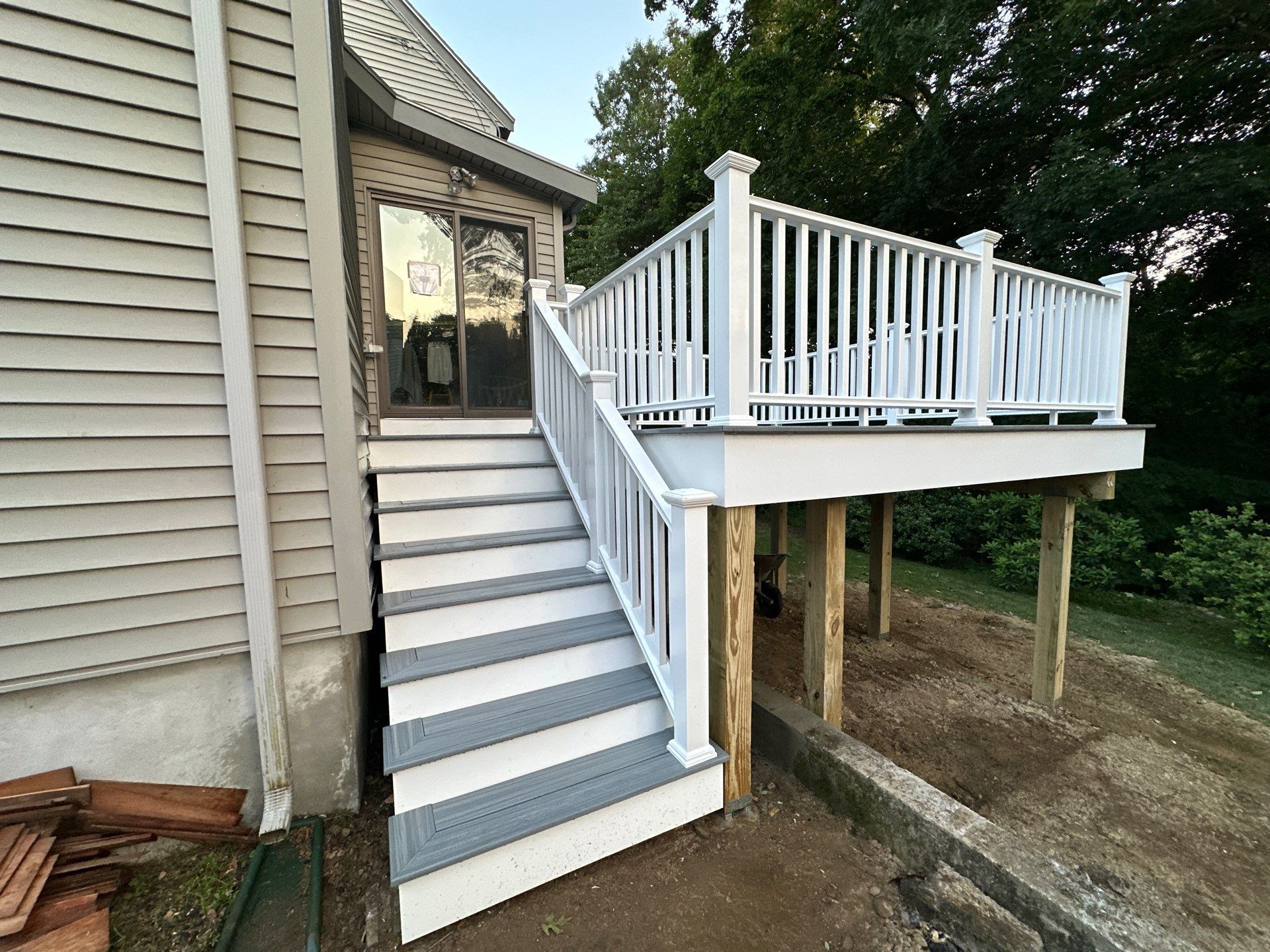 After build: brand new custom white vinyl railing deck with grey composite treads and structural footings