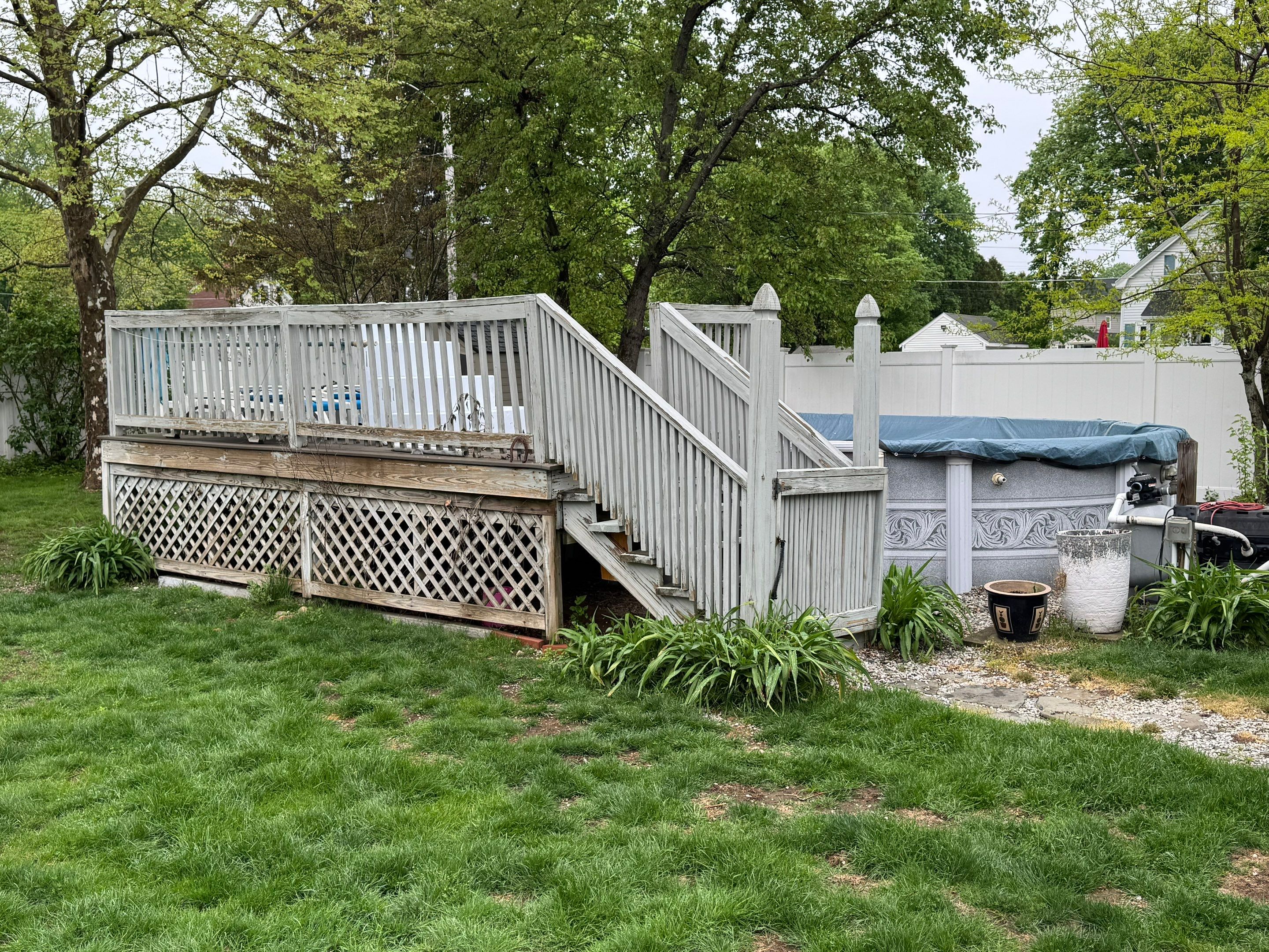 Before build: weathered above-ground pool deck with peeling grey paint, worn stairs, and damaged lattice