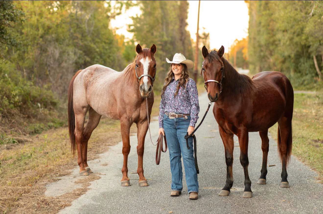 Logan standing peacefully with two ministry horses