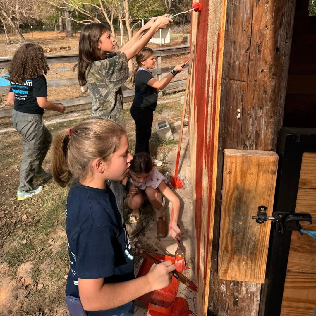 Girls volunteering and painting the barn at Hooves to Freedom