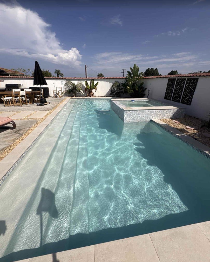 Crystal-clear residential swimming pool with integrated spa and Baja shelf