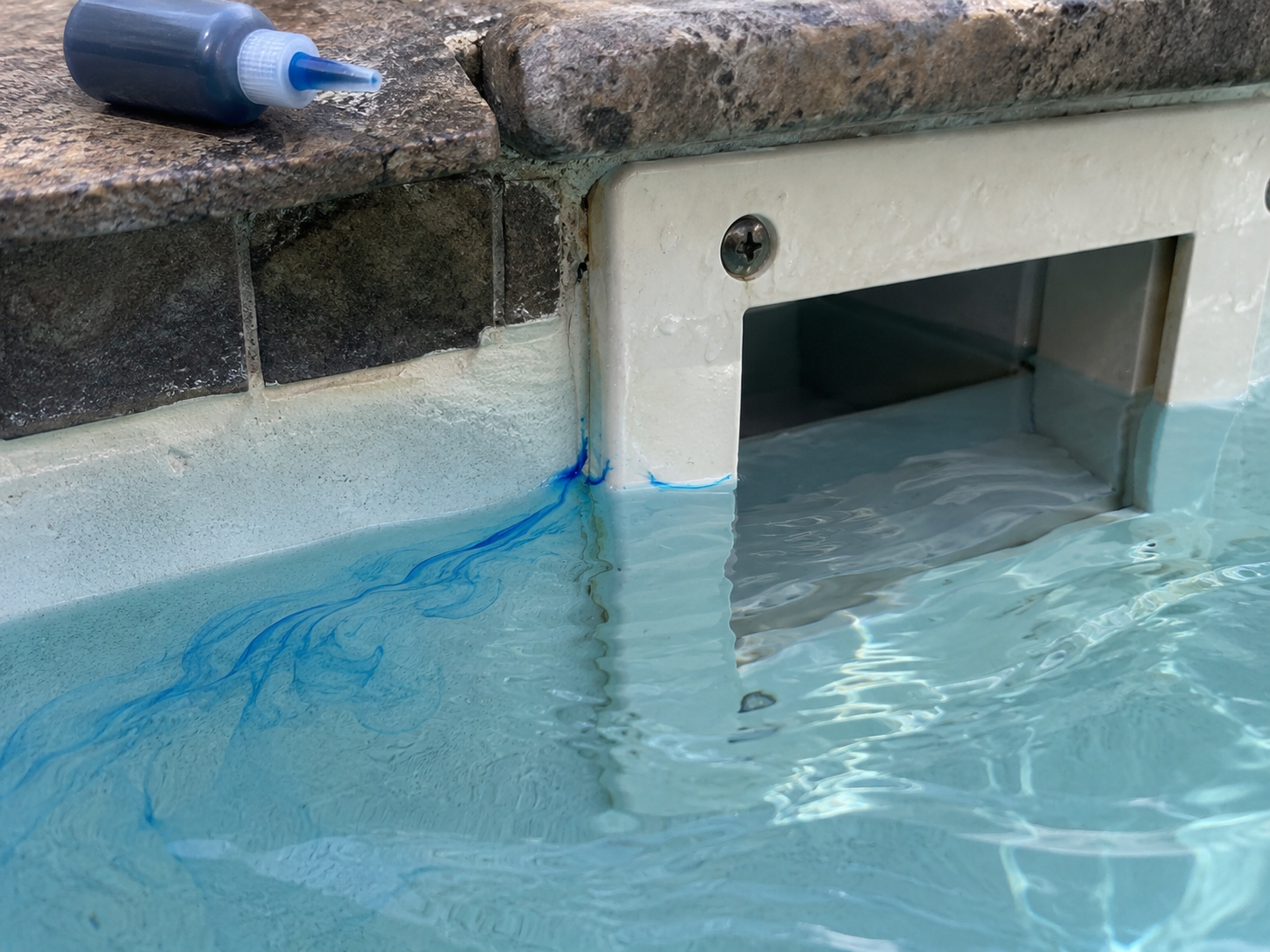 Pool dye testing around skimmer faceplate to pinpoint leak source