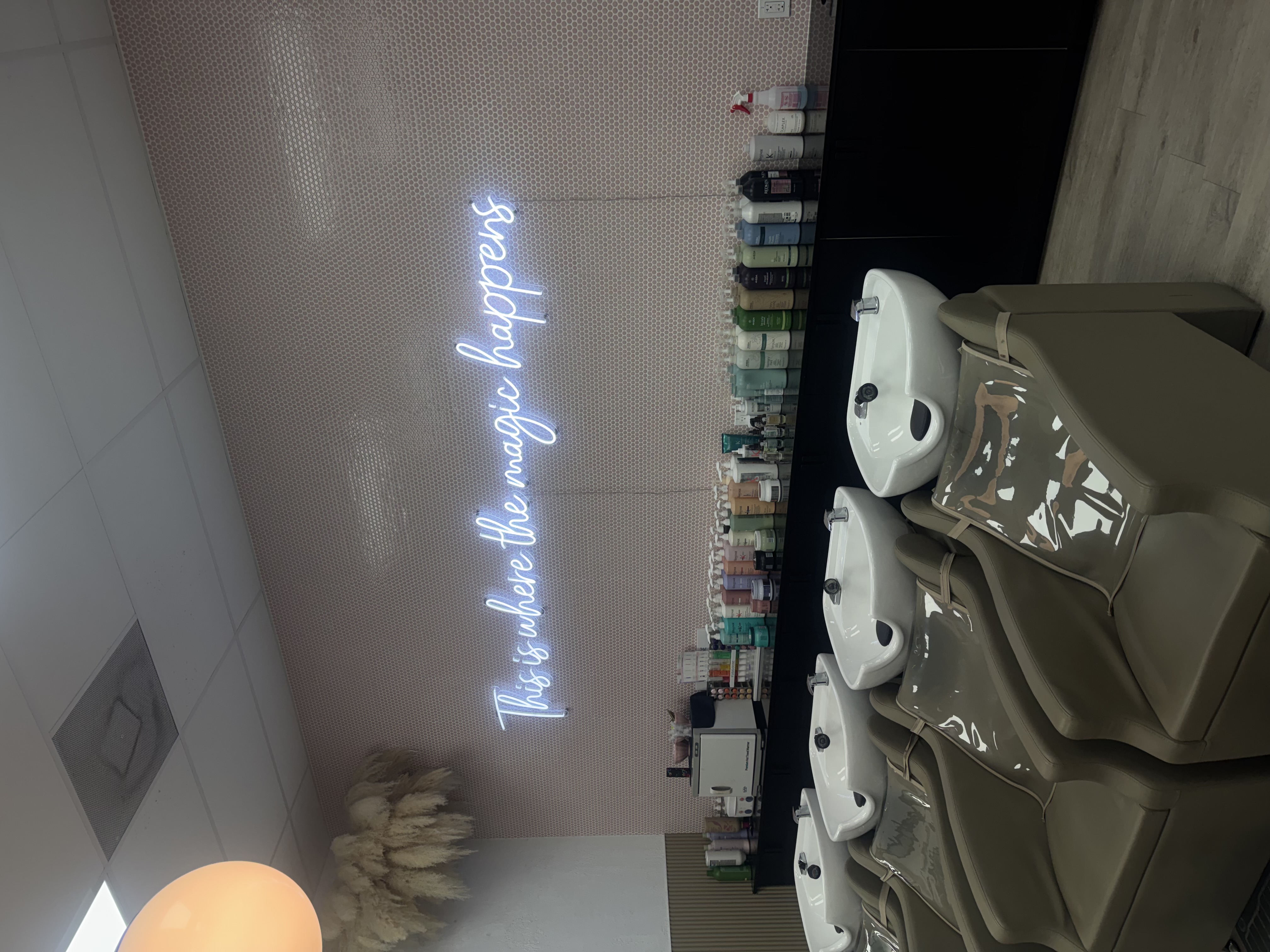 Salt + Waves Salon shampoo lounge and 'This is where the magic happens' neon