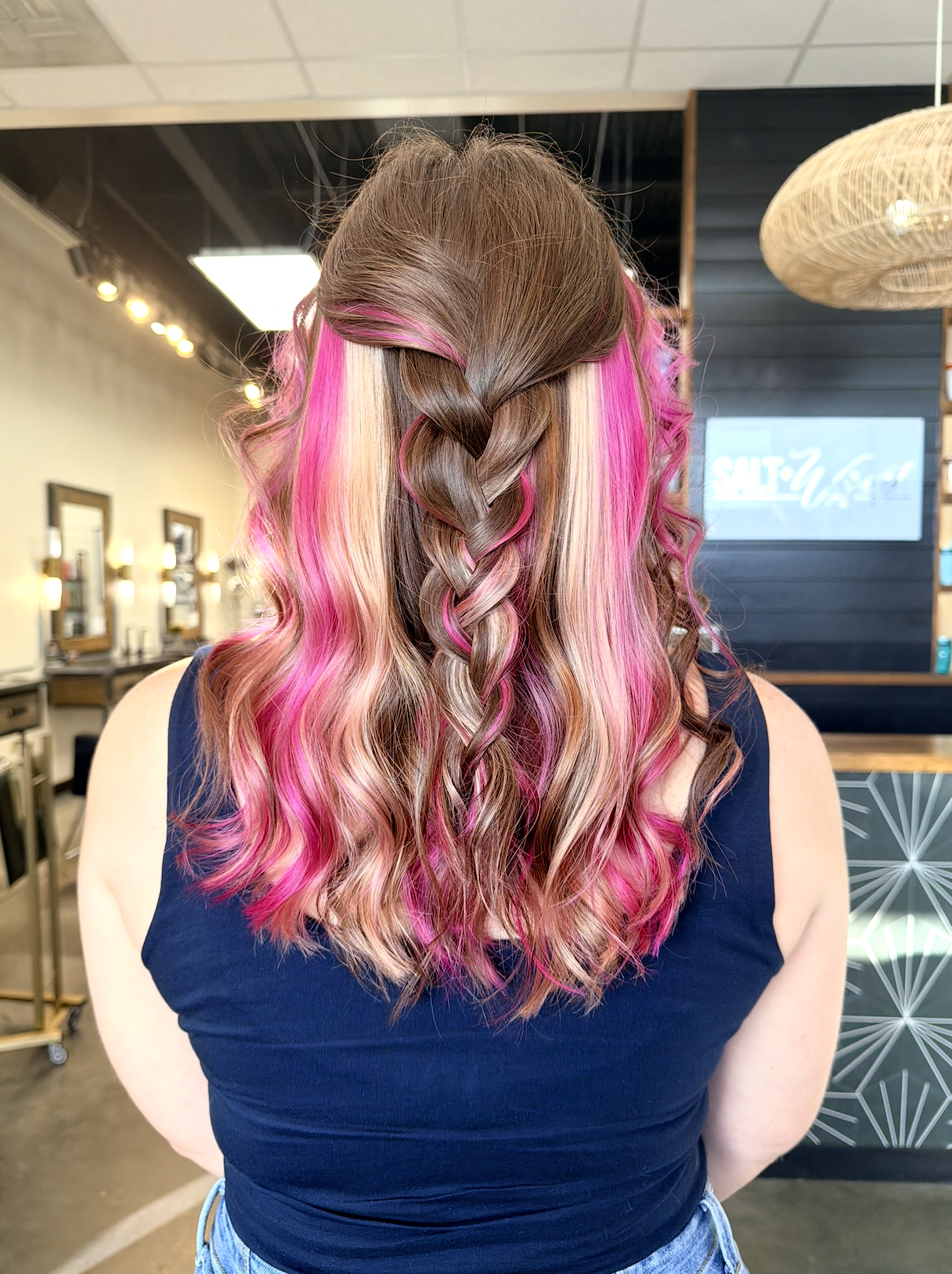 Salt + Waves Salon braided style with pink highlights in salon