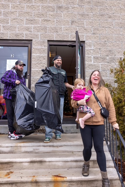 Veteran family leaving with Christmas gifts and packages