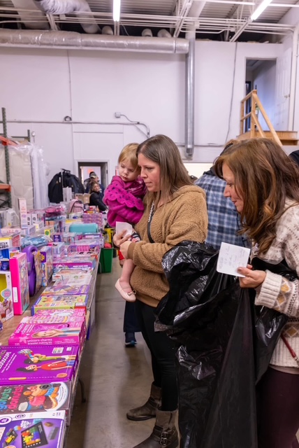 Families and children selecting Christmas toys and holiday gifts at Homeland Heroes Foundation