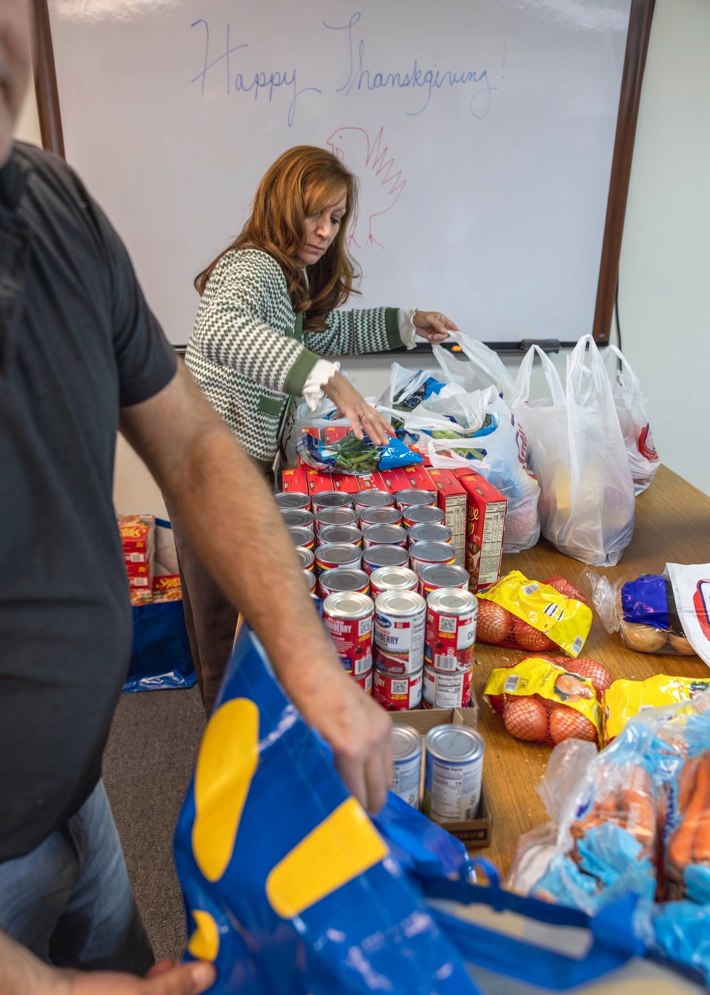 HHF volunteer packing bags of fresh Thanksgiving produce and groceries