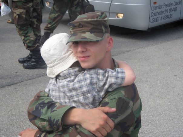 Service member embracing a child