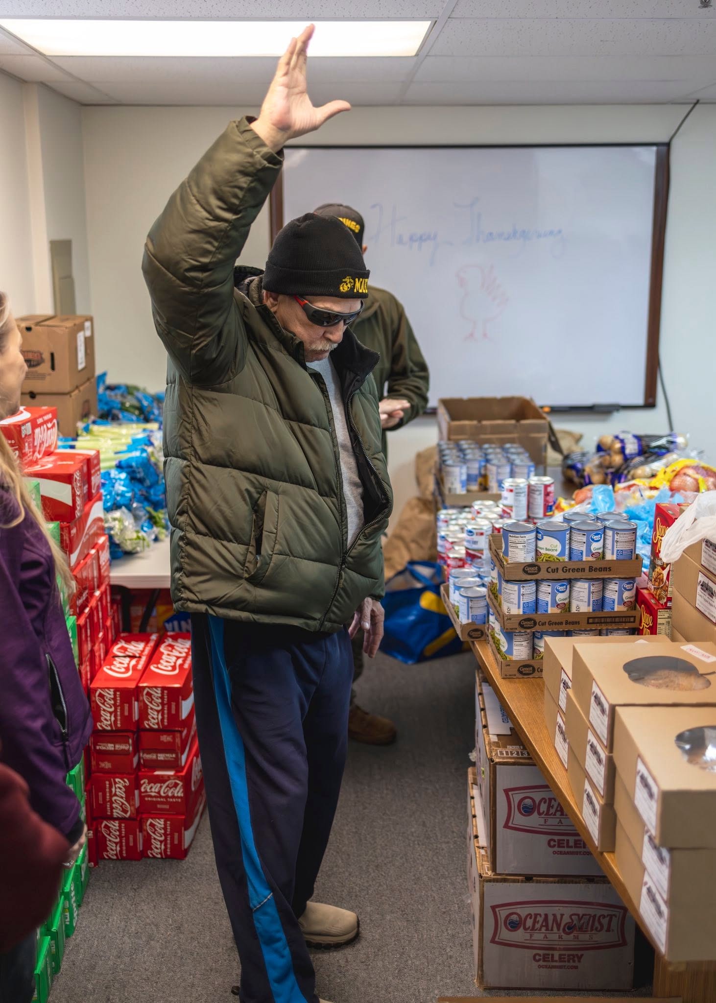 Veteran and volunteer with holiday meal provisions at Homeland Heroes Foundation Thanksgiving Giveaway