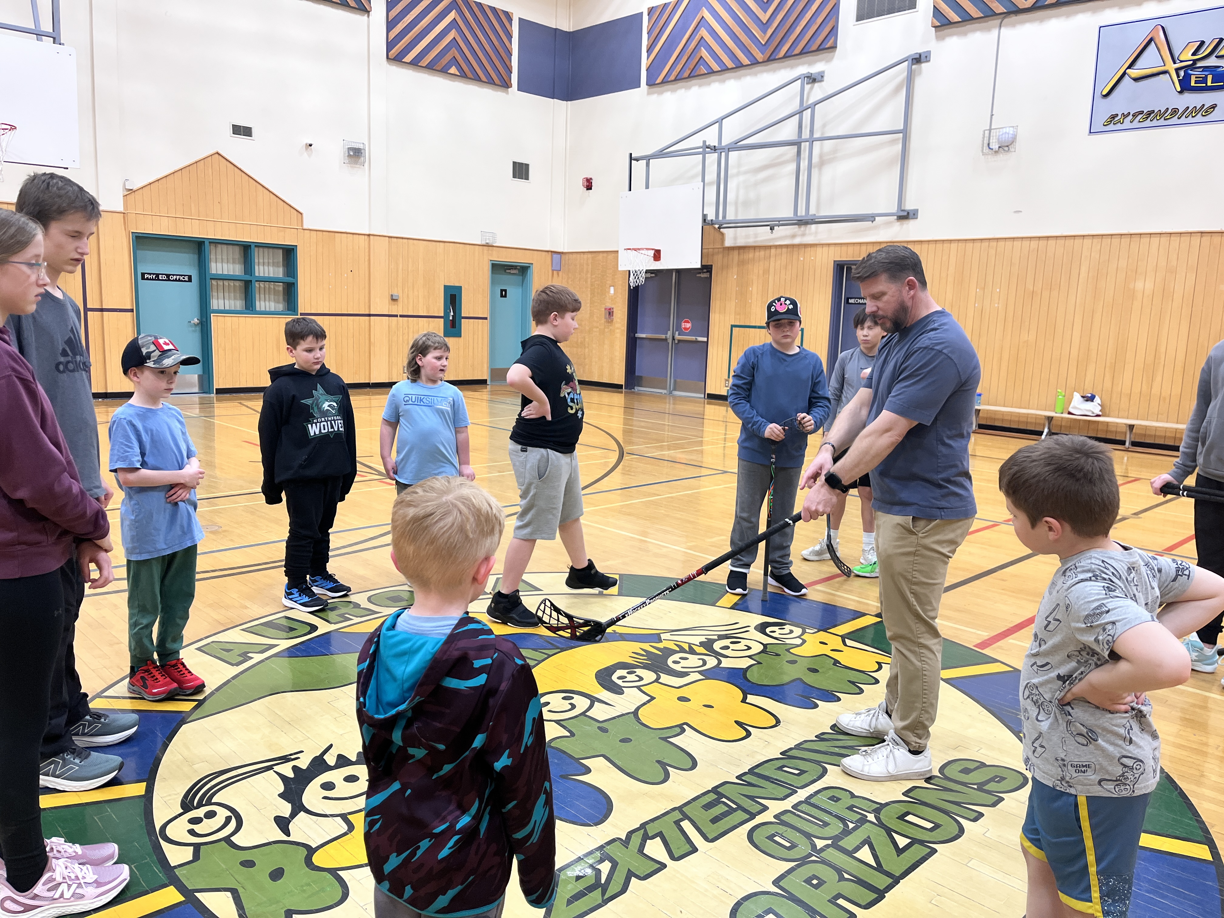 Larry Moberg working with students on the gymnasium floor