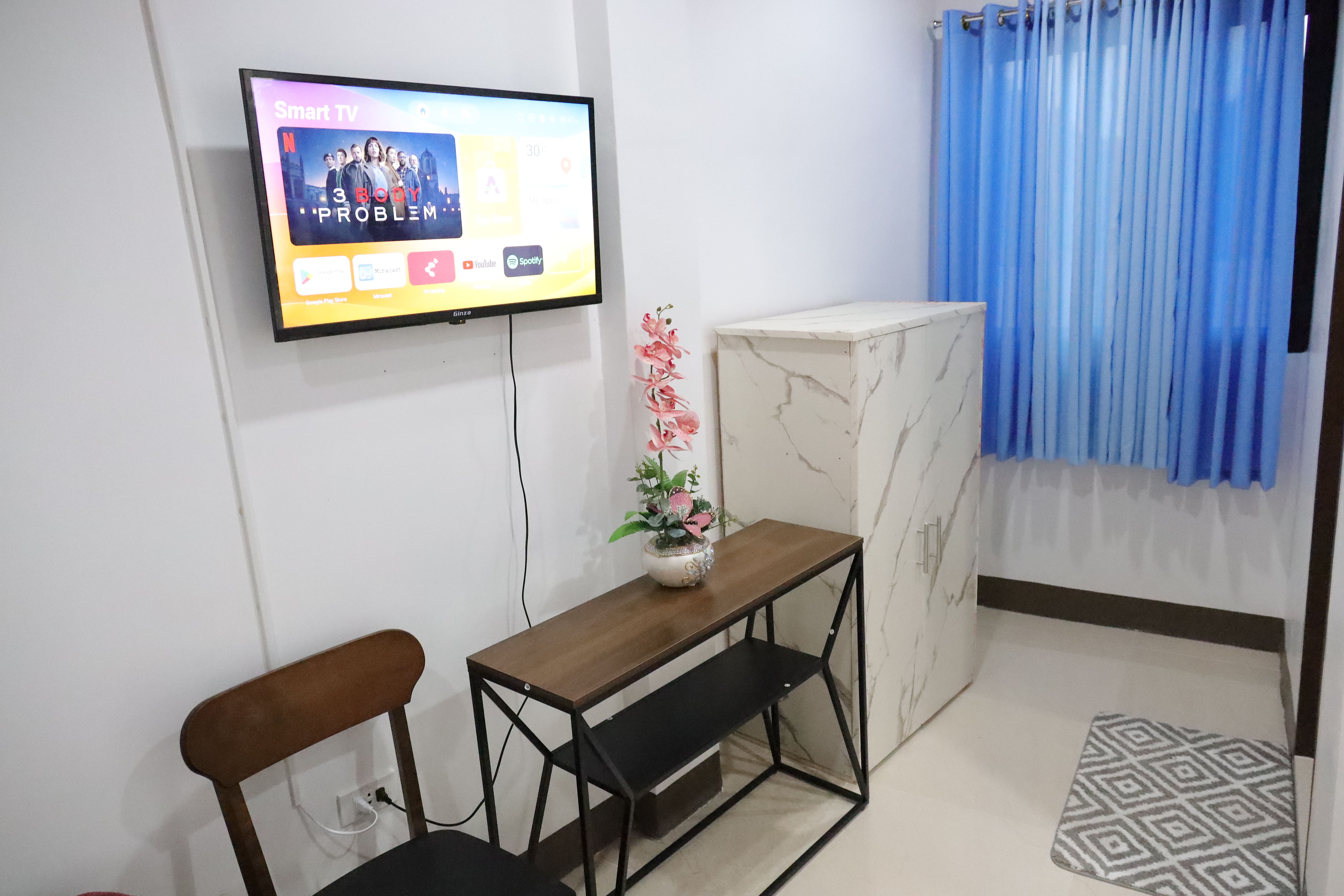 In-room Smart TV, console table, chair, and marble-finish wardrobe cabinet