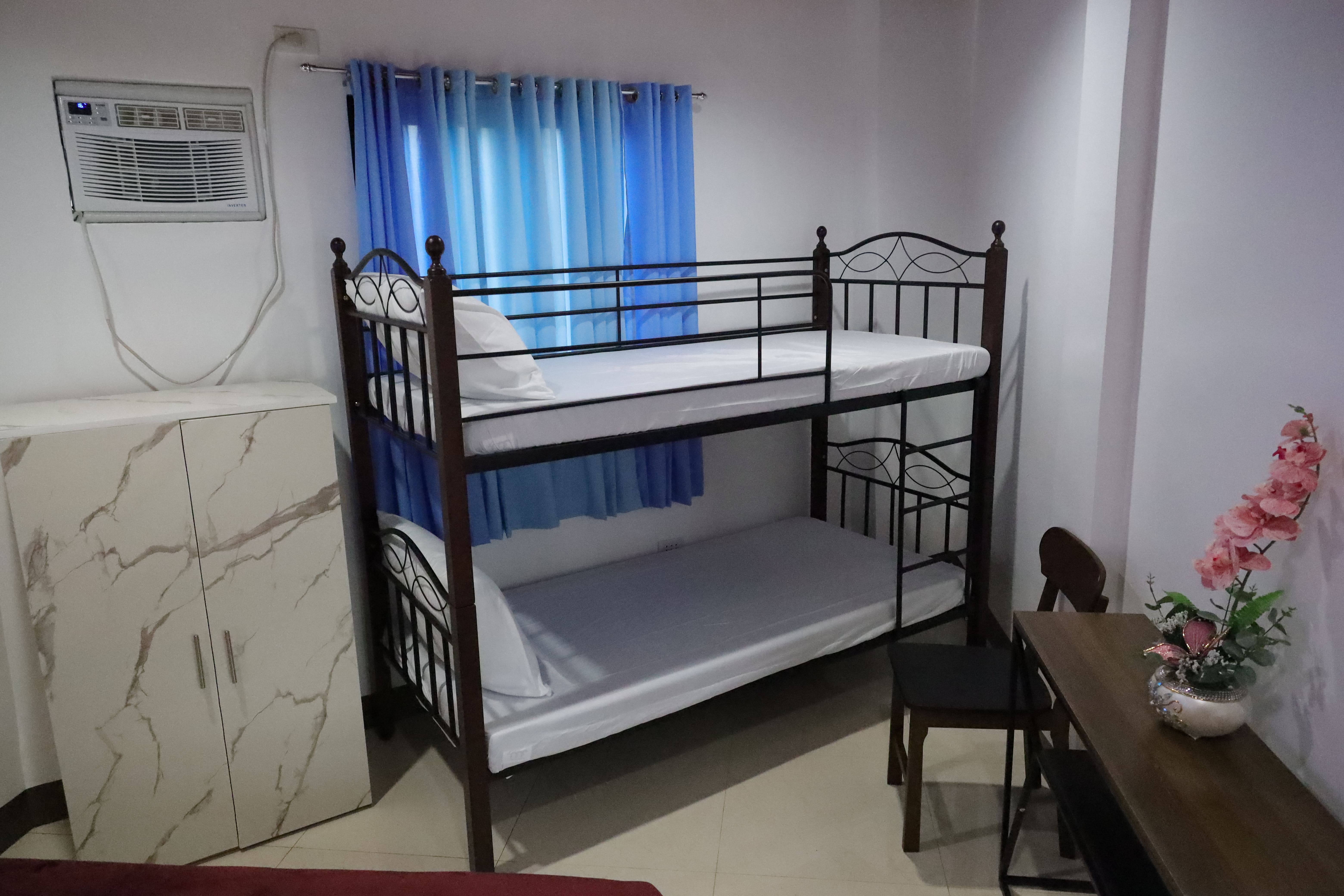 Family Room bunk bed, wardrobe cabinet, air conditioner, and study desk with flowers