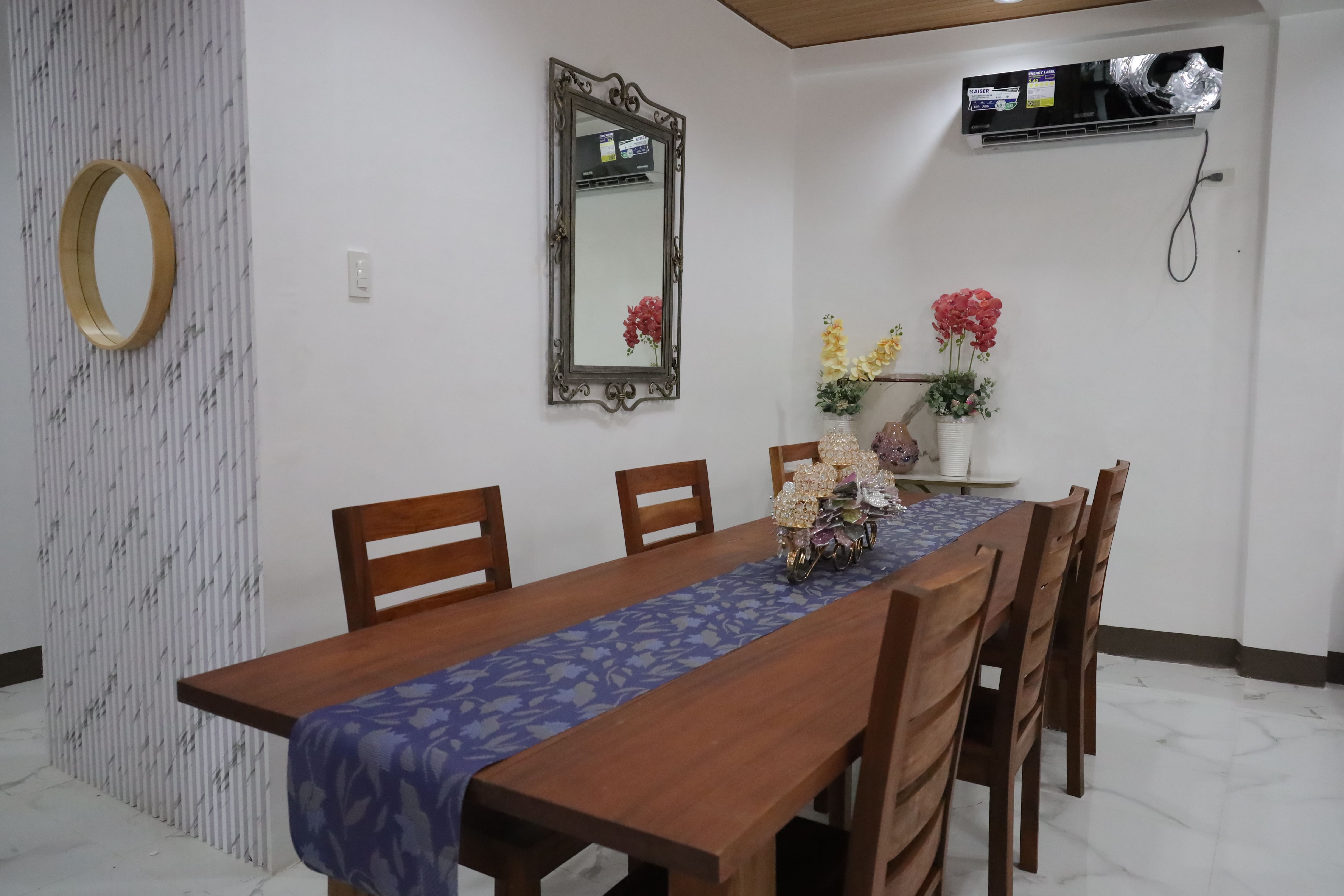 Long wooden dining table with floral centerpiece in the reception area