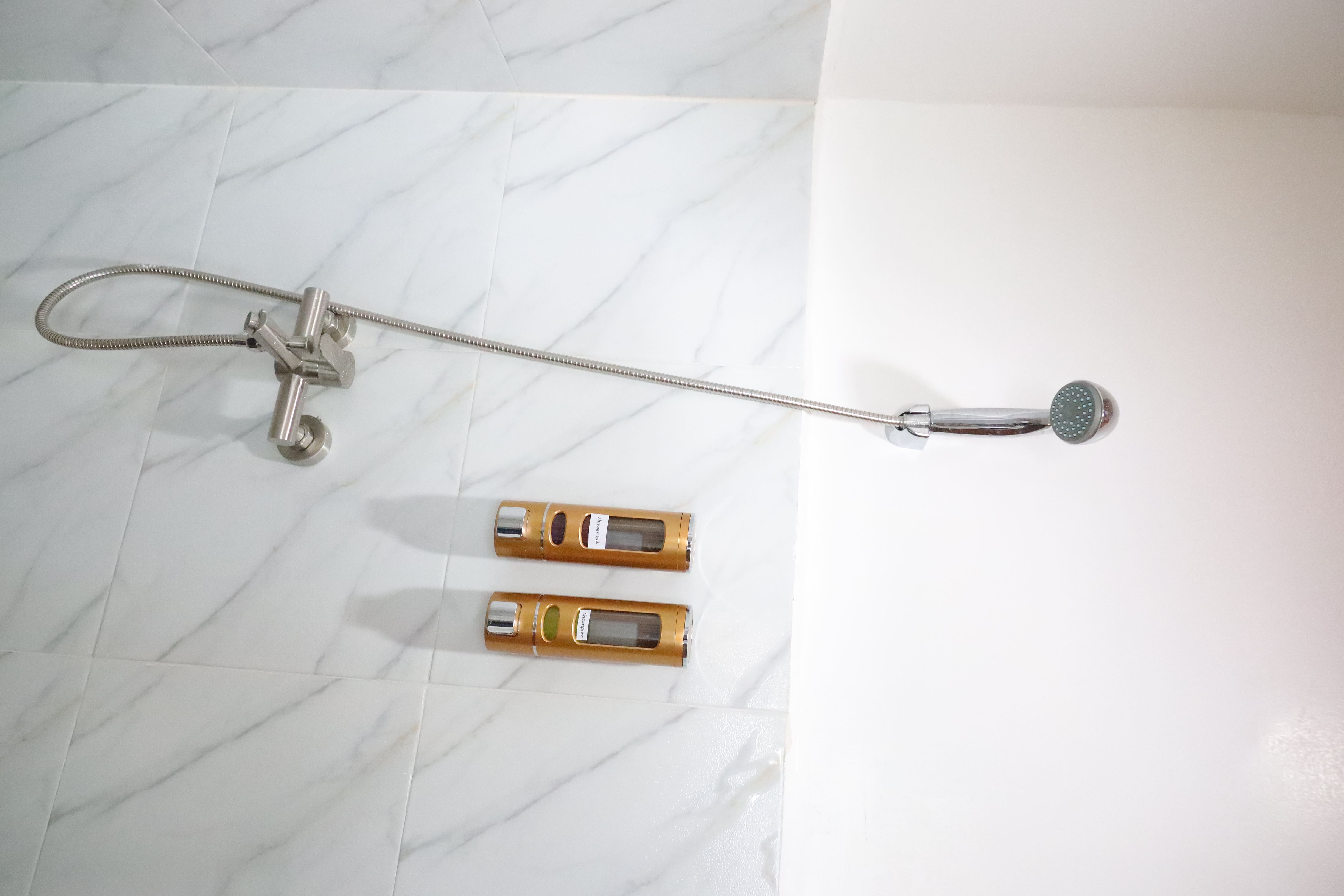Hot and cold shower fixture with complimentary shampoo and shower gel dispensers