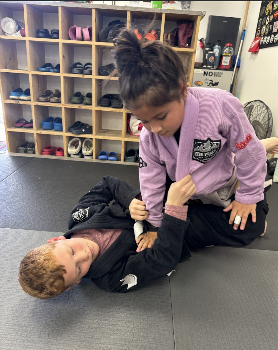 Young students practicing Jiu Jitsu technique together on the mats at Five Peaks