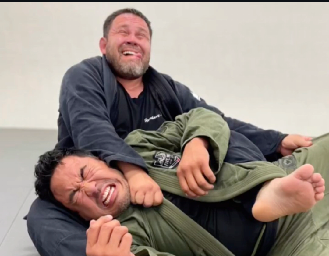 Co-owners Carlos Cabrera and Mark Bondoc sharing a laugh while training on the mat at Five Peaks Jiu Jitsu