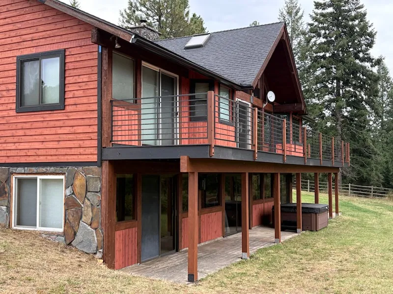 Home exterior after complete siding, trim and deck rebuild with metal railings