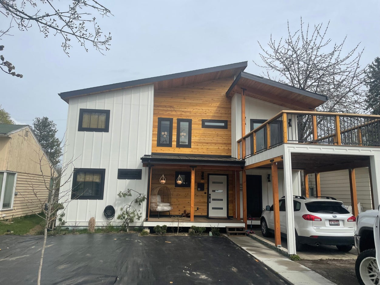 Home with new siding, covered porch and upper deck built by Bruin Builders in North Idaho
