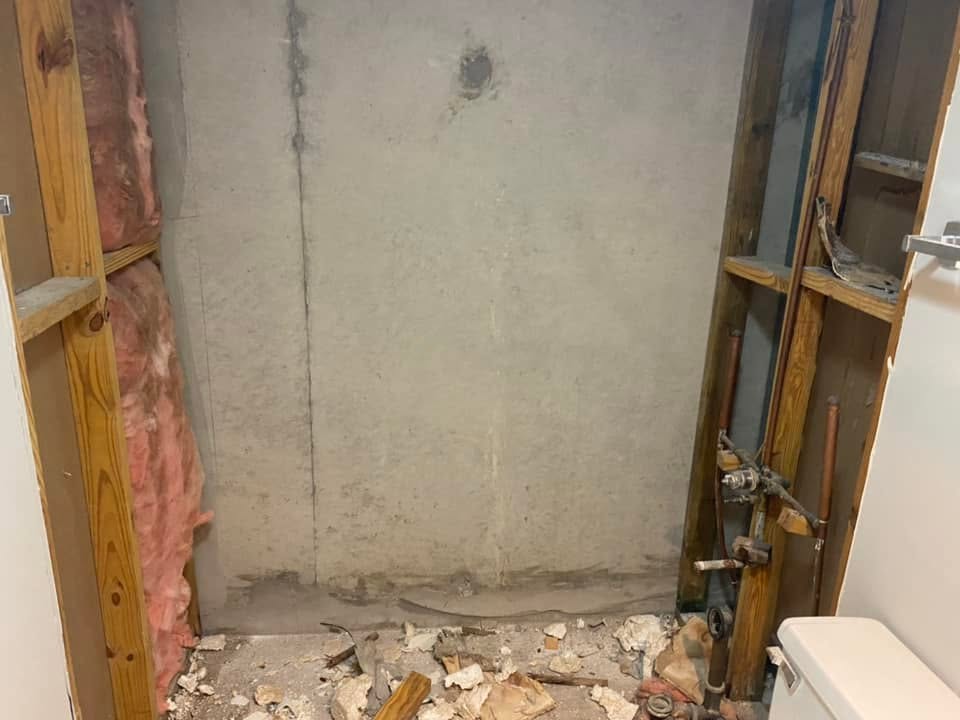 Shower wall stripped down to framing studs during demolition for the remodel.