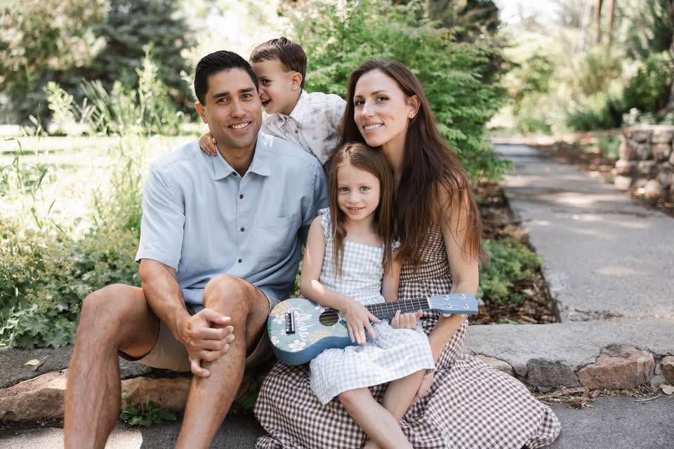 Kawika Burdine with his family on outdoor steps, one child holding a ukulele