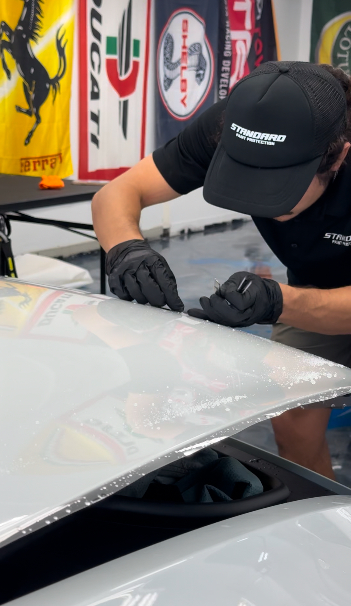 Michael personally installing paint protection film while wearing Standard Paint Protection branding