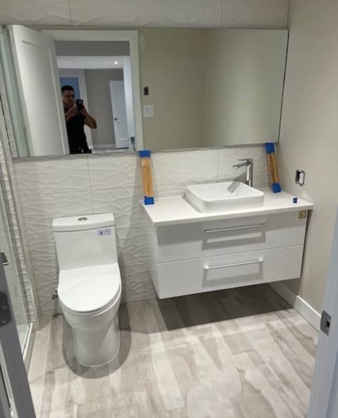 Installation plomberie et meuble vasque suspendu contemporain avec grand miroir et mur texturé 3D